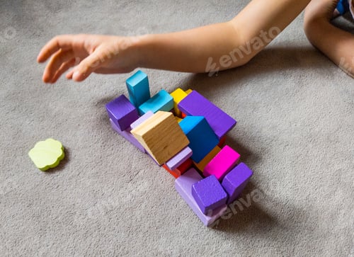 Preview: A child is playing withcolorful heart with colorful wooden building blocks.