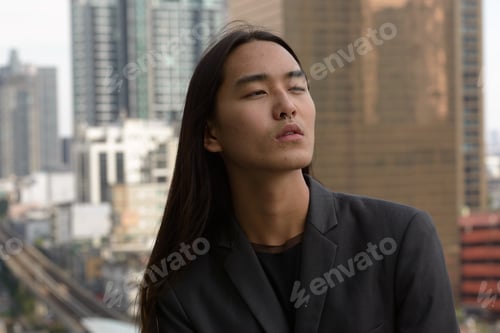 Preview: Portrait of young Asian man with long hair