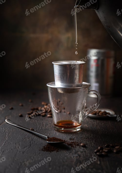 Preview: Preparation of Vietnamese coffe with aluminum cofe filer on dark background