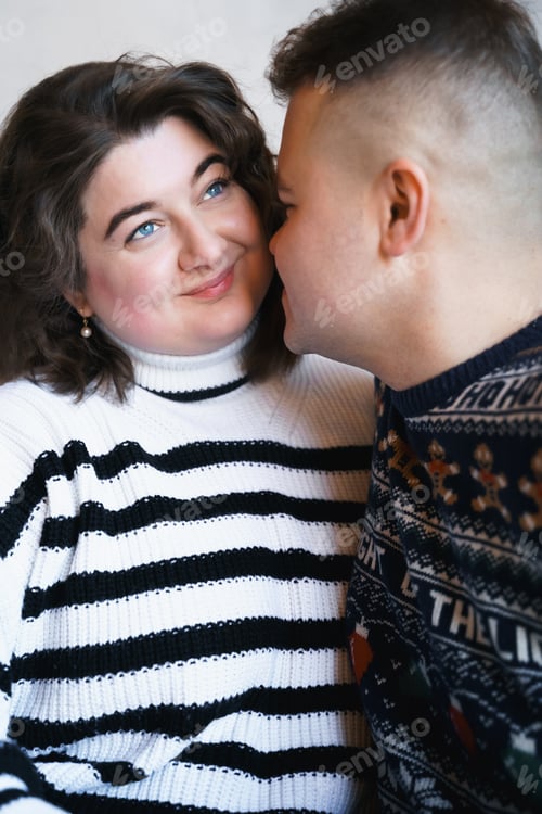 Preview: Loving couple in cozy sweaters. Sweet love moment lovestory. Body positive plus-size smiling woman.