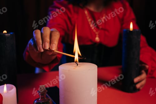 Preview: cropped view of blurred fortune teller lighting palo santo stick near burning candle isolated on