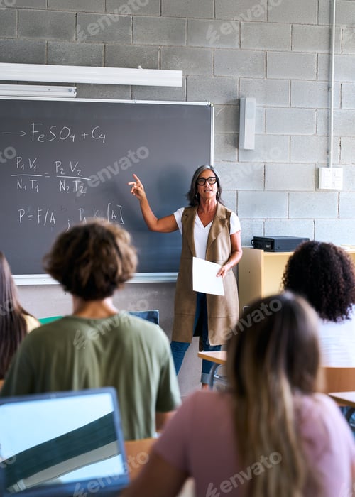 Preview: View from behind a group of multiracial students taking notes in a classroom