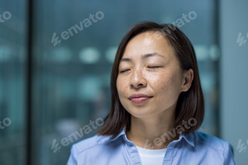 Preview: Asian woman close up with closed eyes breathing and relaxing resting, businesswoman at workplace