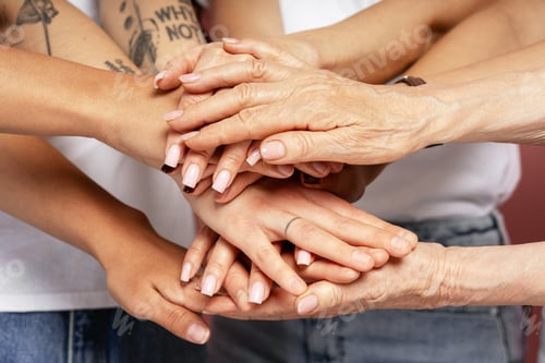 Preview: Group of People Stacking Hands Showing Teamwork and Unity
