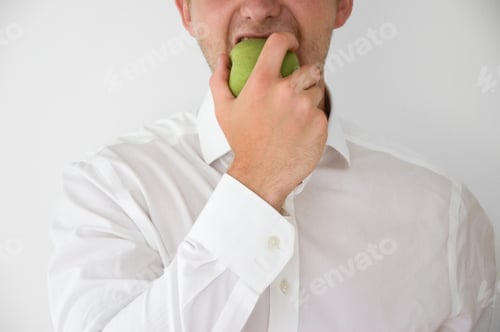 Preview: Businessman eating a green apple