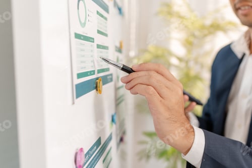 Preview: A business analyst examining charts and statistics on a whiteboard