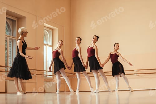 Preview: Group of ballerinas holding hands while dancing on ballet class.