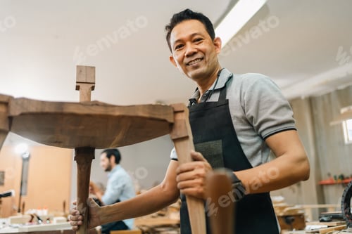 Preview: Carpenter working with wooden plank in workshop. making a furniture from wood