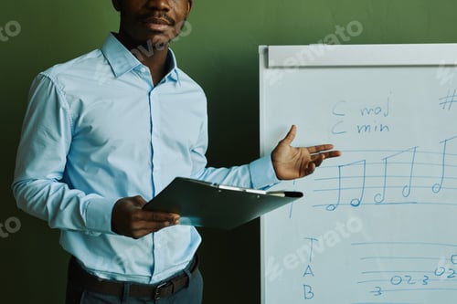 Preview: African American man in blue shirt standing by whiteboard with musical notes
