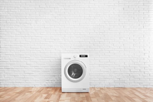 Preview: Modern washing machine near brick wall in empty laundry room