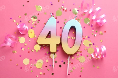 Preview: 40th birthday. Number shaped candles and confetti on pink background, flat lay