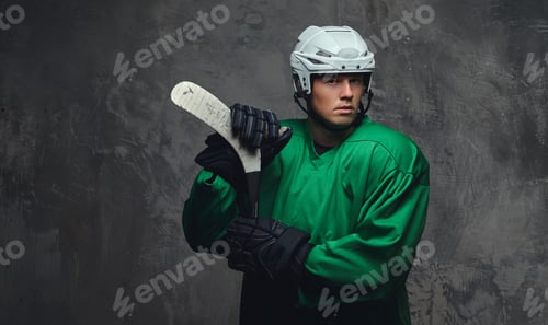 Preview: Hockey player wearing black protective uniform holds a hockey stick on a gray background.