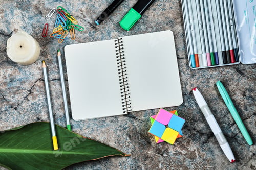 Preview: Empty notebook with pencils, candle, paper clips on the marble background
