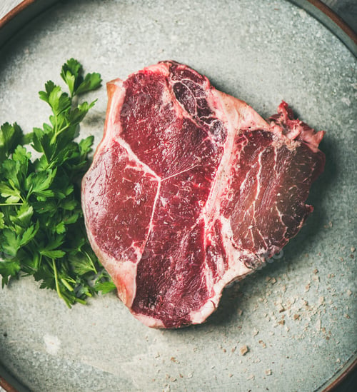 Preview: Flat-lay of raw uncooked dry-aged t-bone prime beef steak