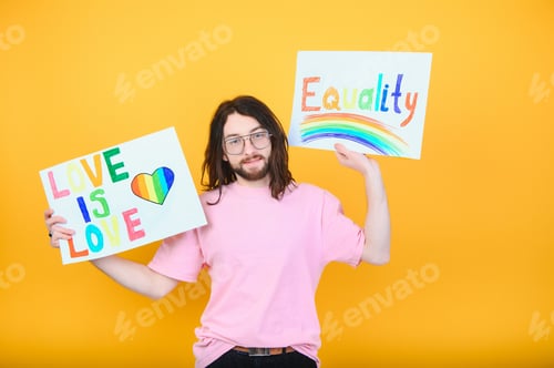 Preview: Attractive gay caucasian man holding a protest sign during a LGBT pride parade. Equality.