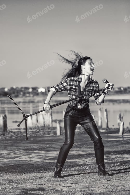 Preview: Singing girl near river. Black and white portrait of emotional rocker woman
