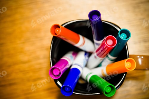 Preview: Closeup selective focus shot of colorful markers and pens in cups