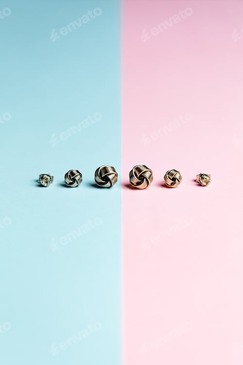 Preview: Minimalistic shot of a group of earrings over a pastel pink and blue background