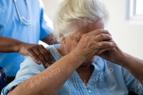 Preview: Nurse consoling senior woman at nursing home