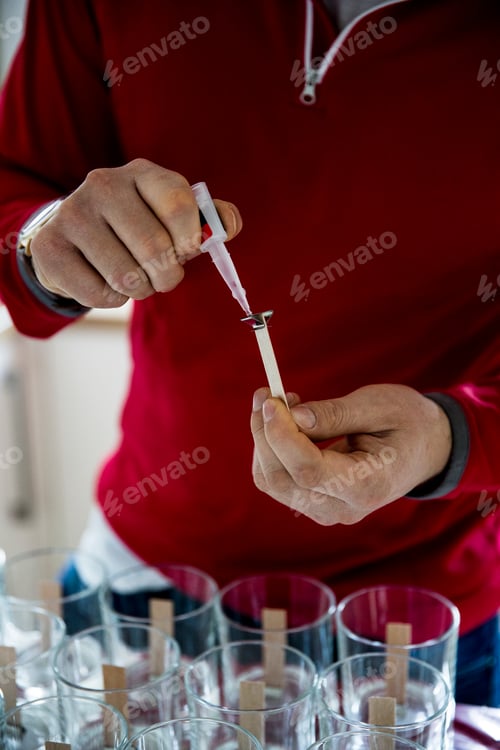 Preview: Man standing in a domestic kitchen, making jar candles.