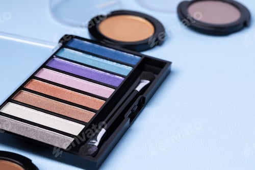 Preview: Set of eyeshadows on blue background close up