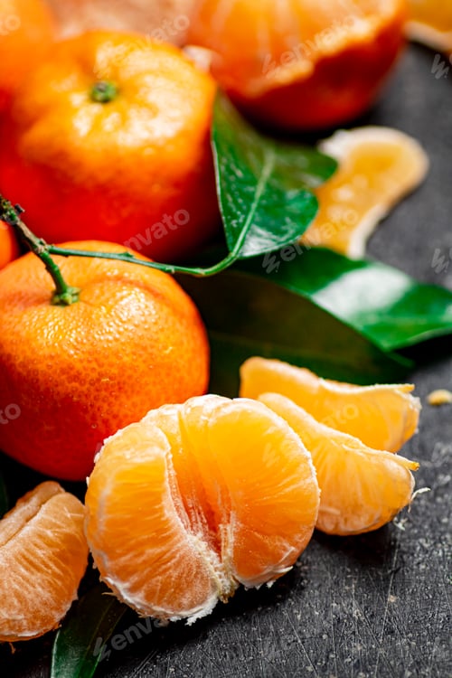Preview: Ripe tangerines with foliage. On a black background.