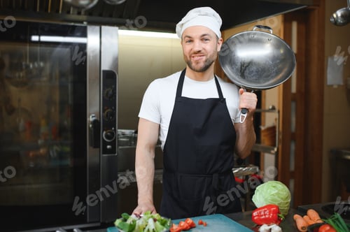 Preview: Portrait of handsome positive chef cook at the restaurant kitchen