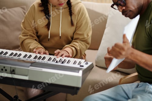Preview: Teenage Girl Plays Keyboard as Adult Watches