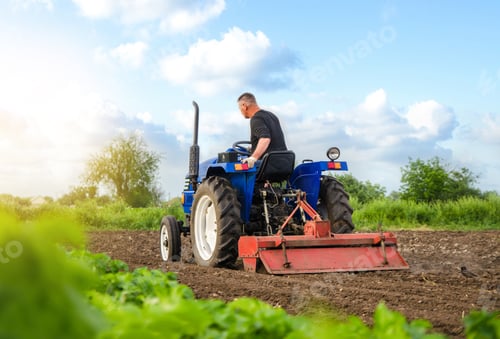 Preview: A farmer on a tractor works in the field.