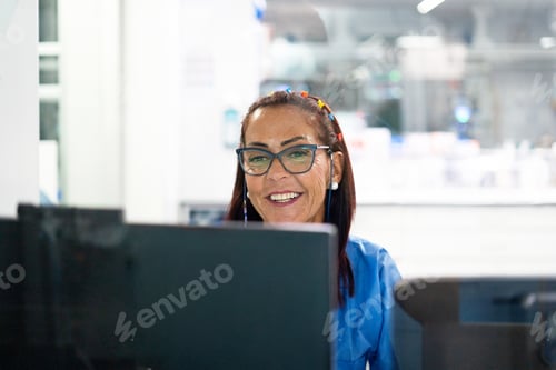 Preview: Smiling woman working on computer in office setting