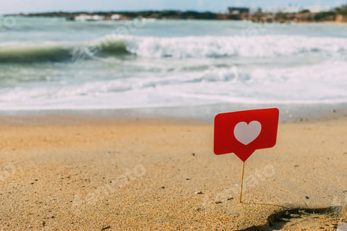 Preview: red heart on stick on sand near mediterranean sea