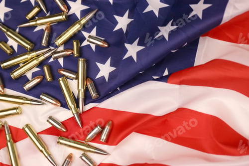 Preview: Many yellow 9mm and 5.56mm bullets and cartridges on United States flag
