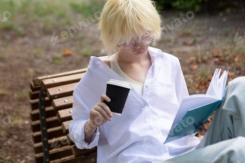 Preview: Teenage girl with blond hear drinking coffee from craft paper cup outside.