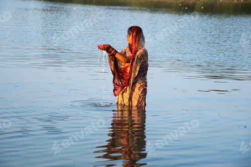 Preview: Traditionally dressed Indian woman pray into the river on Chhat Puja Festival.