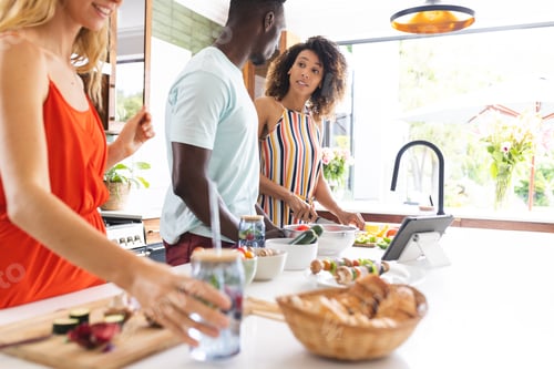 Preview: Young African American man and biracial woman stand together in a kitchen