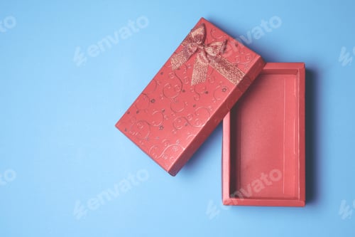 Preview: Top view of open red gift box on blue background. Free space for text