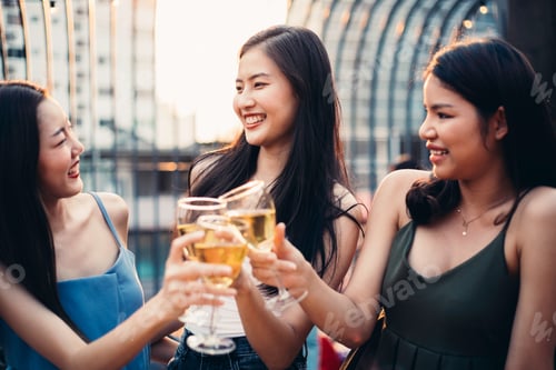 Preview: Group of Asian girls toasting drink together at a party