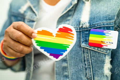 Preview: Asian lady wearing rainbow flag wristbands and hold red heart, symbol of LGBT pride month