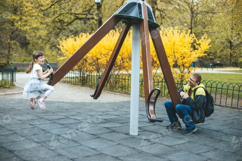 Preview: Little girl and her father riding on a carousel