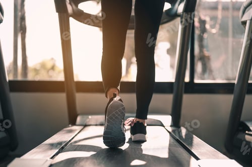 Preview: Close-up Legs and feet of women walking on the treadmill in the gym for good health and strength.