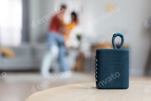 Preview: Selective focus on modern gadget portable speaker over dancing lovers