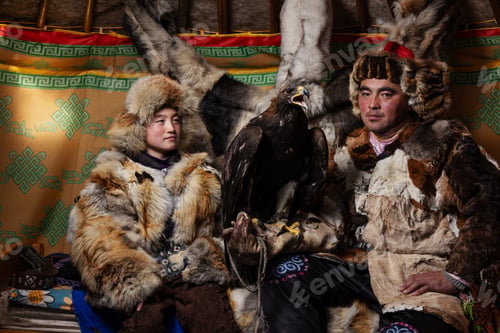 Preview: Inside a traditional Mongolian ger, an eagle hunter and child, both wearing fur clothing