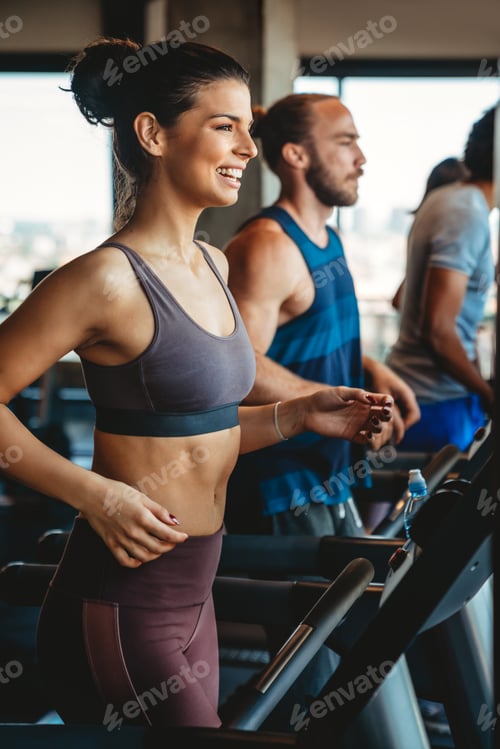 Preview: Group of young people running on treadmills in sport gym