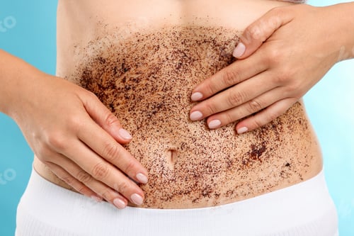 Preview: Woman applying body scrub onto her belly against light blue background, closeup