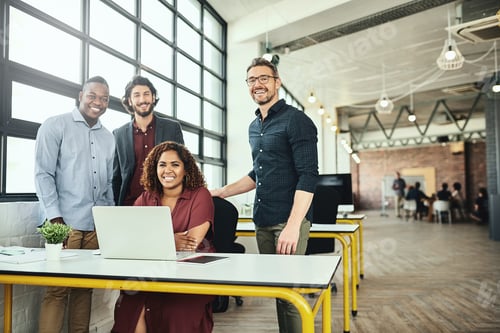 Preview: Cropped portrait of a group of businesspeople standing around a desk in their office