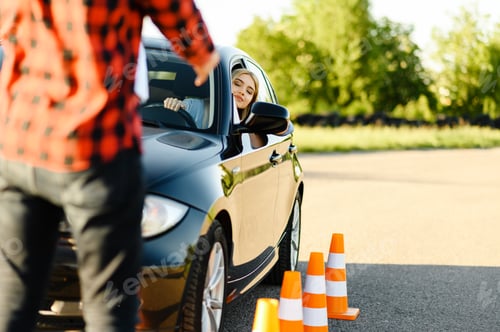 Preview: Male instructor and woman in car, traffic cones
