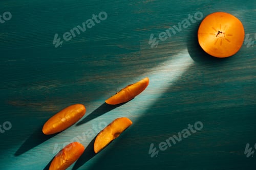 Preview: top view of persimmons on turquoise table with light