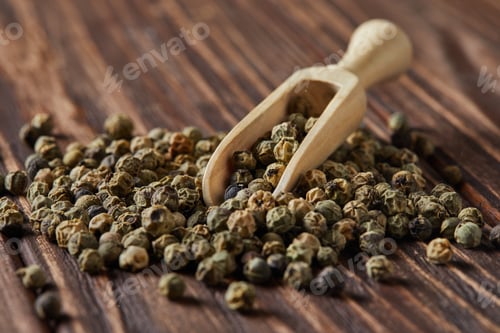 Preview: Green peppercorns with wooden spatula scattered on wooden vintage background