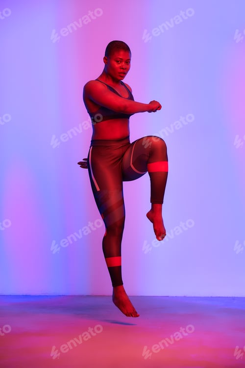 Preview: Happy african american woman wearing sportive clothes showing plus size hips. Body positive concept