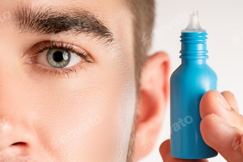 Preview: Male eye and small bottle of eyedrops